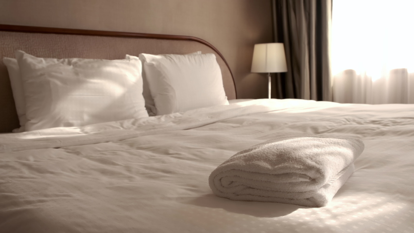 Woman putting a fresh towel on the bed sheet. Room service. | Shutterstock HD Video #1072051048