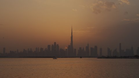 Day to night timelapse of Dubai skyscrapers during sunset. Time lapse of Dubai cityscape in warm golden hour light in Dubai, UAE in 2021
