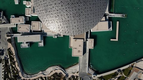 Abu Dhabi, United Arab Emirates - April 6, 2021: Roof and top view of Louvre museum in Abu Dhabi emirate of the United Arab Emirates at sunrise aerial drone footage 