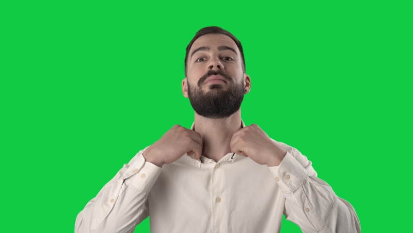 Confident business man getting dressed buttoning shirt sleeve and collar. Portrait isolated on green screen background. 