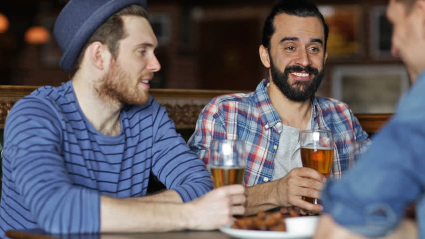People, leisure, friendship and celebration concept - happy male friends drinking beer, eating bread snack and clinking glasses at bar or pub | Shutterstock HD Video #10720703