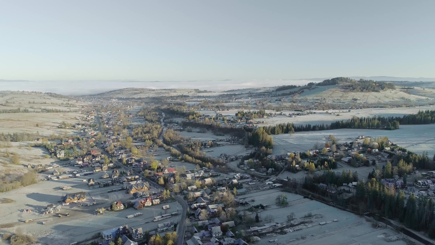 Snowcapped Witow rural village and landscape, Poland. Aerial backward