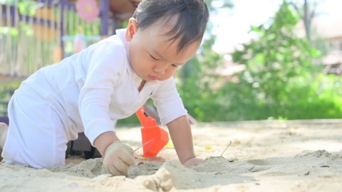 Asian Baby boy playing with sand in a sandbox,Healthy active baby outdoors plays toy