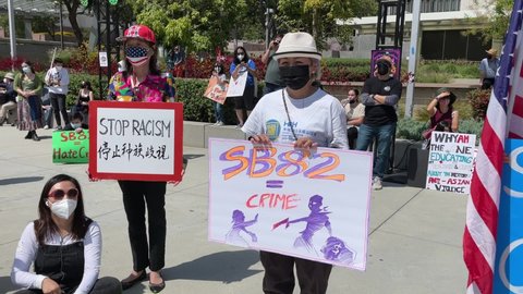 People holding signs take part in a Youth against Hate rally to raise awareness of anti-Asian violence in Los Angeles, on May 8, 2021.