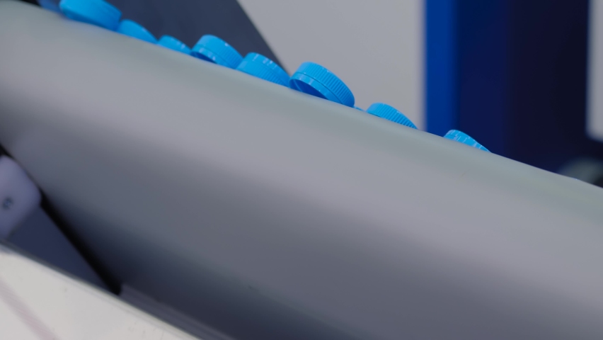 Many blue plastic bottle caps falling from conveyor belt at exhibition, factory - production line - close up. Manufacturing, recycling, industry, technology equipment concept | Shutterstock HD Video #1072112243