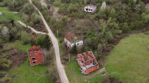 Aerial drone view of Houses and buildings destroyed and burned in war by artillery. Ruined and damaged villages as war aftermath in Bosnia and Herzegovina. Abandoned buildings. House in ruins.