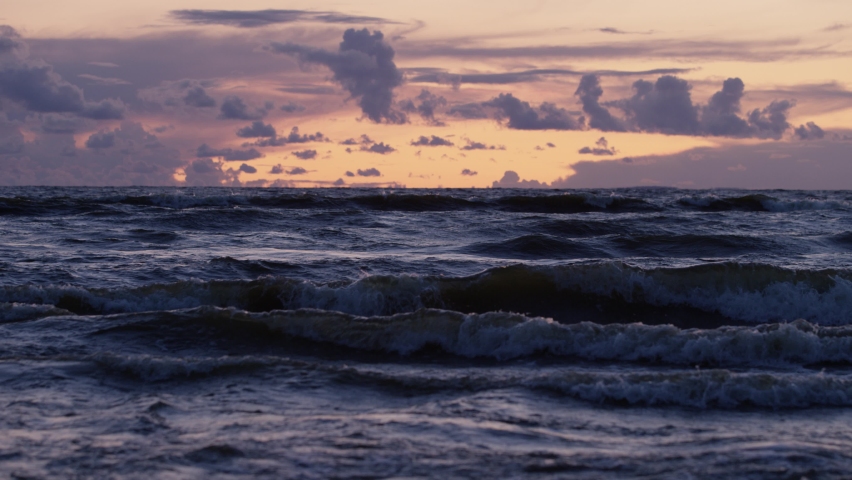 A beautiful sunset at the Gulf of Finland. Russian natural seascape. Saint-Petersburg twilight on a seaside. Golden hour waves ubder storm clouds. | Shutterstock HD Video #1072120673