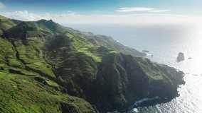 Drone shot of Flores Island covered green vegetation at sunny day, Azores, Portugal, Europe. Birds eye view of amazing landscape green mountains at atlantic ocean, 4k footage