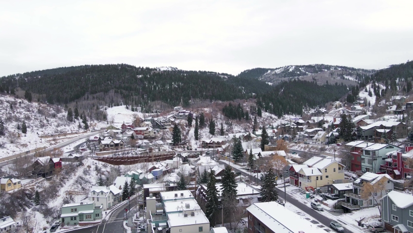Park City snowy with mountains in background, Utah. Aerial circling