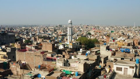 Minaret Of A Mosque With Cityscape At Daytime In Rawalpindi, Pakistan. - aerial approach