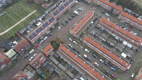 Drone orbiting suburban neighbourhood with solar panels on rooftops