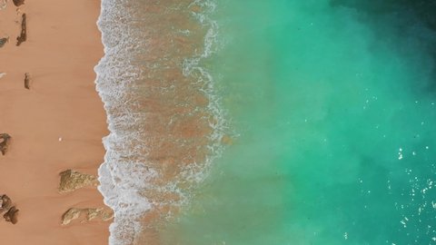 Aerial view of sea and sand beach at sunset. Pink sand beach with ocean wave foams. Beautiful top view of sunset pink sand beach. Perfect for holiday summer background, Tropical destination.