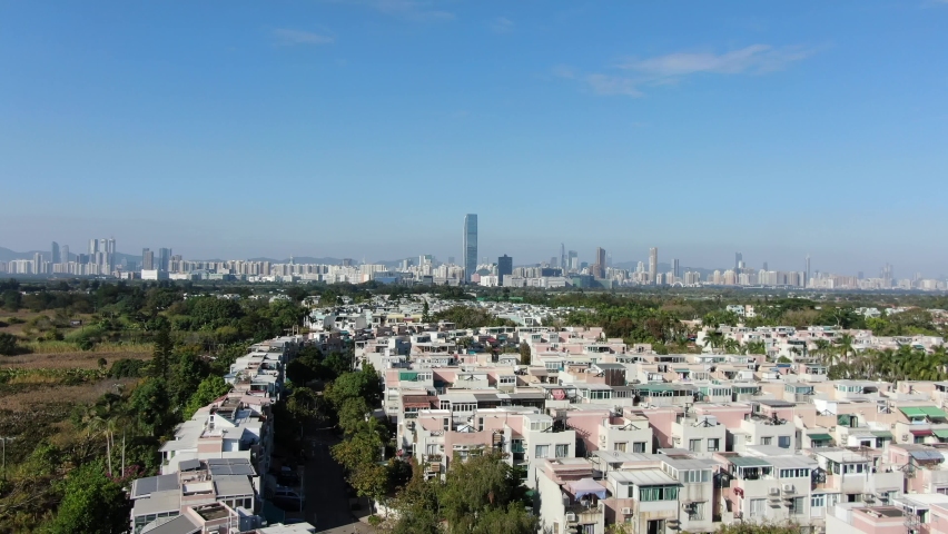 Hong Kong and Shenzhen border line over Hong Kong rural houses with Shenhzen skyline in the horizon, Aerial view.