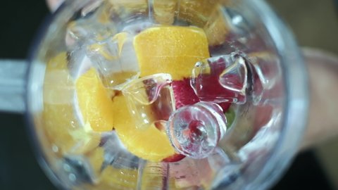 Frozen blended in slow motion shot from above using fruit strawberries, orange and yoghurt with ice.Camera birds eye view. good for health. 4K.