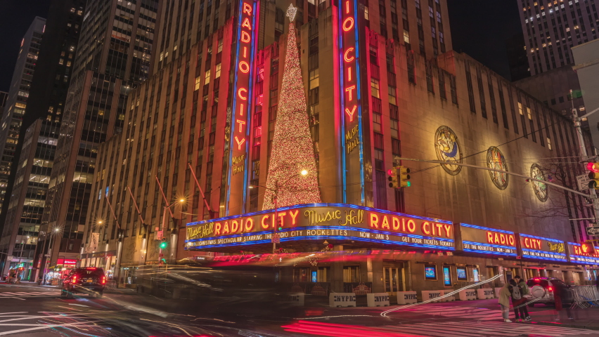 Manhattan, New York United States Nov 29 2019 :Timelapse of vehicle traffic and walking people in front of Radio City Music Hall at 6th Avenue in New York City, USA.