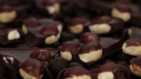 crushed dark chocolate with nuts close up. Sliding shot. 4K UHD video