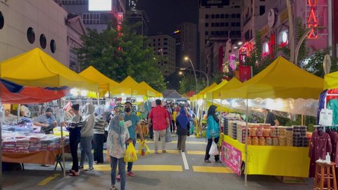 KUALA LUMPUR,MALAYSIA - MAY 8th 2021 : People's on scene shopping for Hari Raya festival celebrated in Malaysia. Location at Jalan Tunku Abdul Rahman. contains noise and film grain due to High ISO..