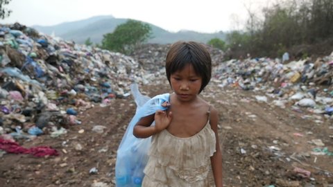 Asian Poor Kid Carry Garbage Bag Walking, Garbage At Background
