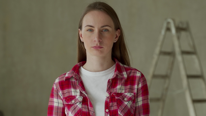 Surprised young woman makes home repair. 