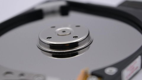 Video of Opened Hard Disk Drive with spinning platter. Close up of a hard disk drive reading and writing data. Disassembled hdd reading head.
