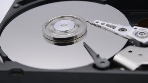 Video of Opened Hard Disk Drive with spinning platter. Close up of a hard disk drive reading and writing data. Disassembled hdd reading head.
