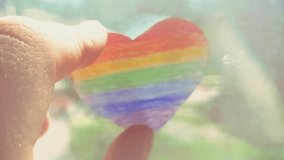Hand holds a rainbow heart. LGBT symbol. Flag of Liberty. International Day Against Homophobia - Powered by Shutterstock - Get 15% off with code: PIKWIZARD15