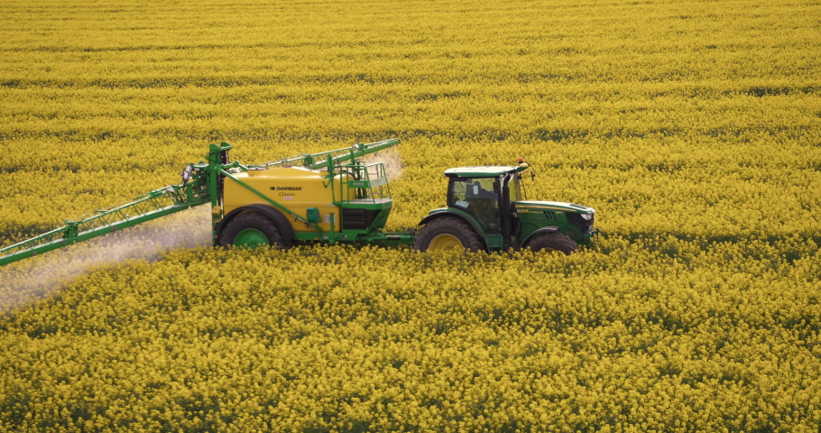 agriculture aerial flying by close tractor in the rapeseed field farming famer germany 4k Royalty-Free Stock Footage #1072174676