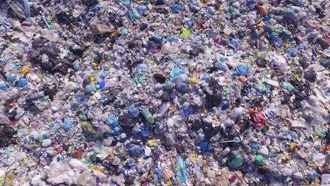 AERIAL: Big piles of empty bottles, bags and other plastic in the garbage dump