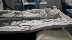 This panning video shows a paleontology fossil specimen laid out on a work table in a research laboratory.