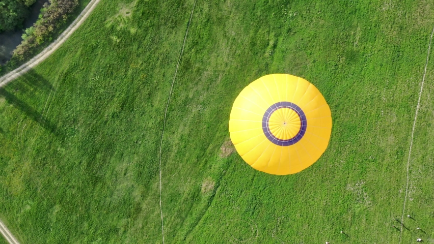 Aerial photography of hot air balloons. Top-down view. Shooting with a drone. The balloon is yellow. Beautiful landscape.