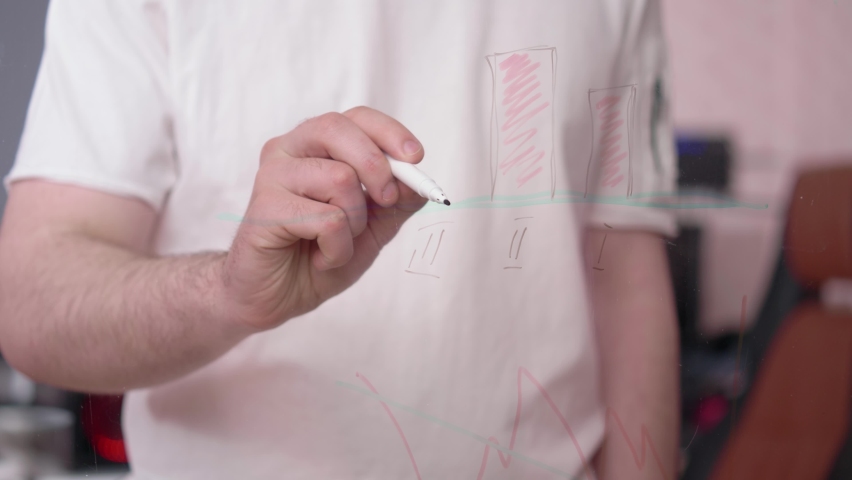 The hand of a young white guy is writing graphics, the concept of learning work and studying distance