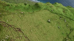 Top view of green hills of mountains of Flores Island, Azores located in atlantic ocean, Portugal, Europe. Aerila shot of ocean waves rolling on island coast. Natural background, 4k footage