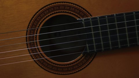 Playing a classic guitar, sound hole view