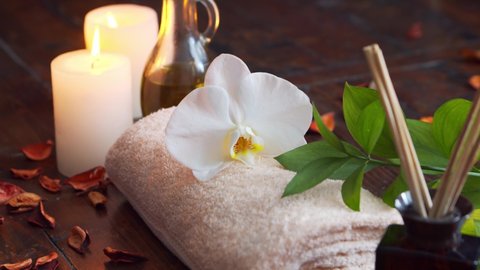 Spa background. Towel, candles, flowers, massaging stones and herbal balls. Massage, oriental therapy, wellbeing and meditation.