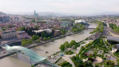 Aerial video footage. Drone flies above Tbilisi Georgia city center. Rike park, river kura, futuristic Exhibition hall and Music concert. Bridge of peace. Air balloon. Beautiful old city panorama 