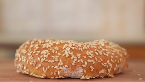 Sesame Seeds Falling on Freshly Baked Bagel, Close Up with Copy Space