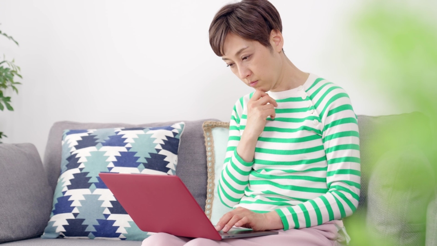Middle-aged Asian woman worried while using a laptop PC. Royalty-Free Stock Footage #1072217492