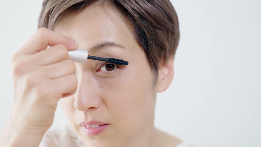 Middle-aged Asian woman putting mascara. | Shutterstock HD Video #1072217504