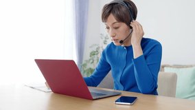Middle aged Asian woman calling with video conference. Telemeeting. Remote working.