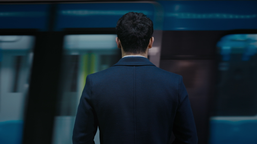 Back view of male entrepreneur in formal wear standing on metro station with moving train on background. Missing of public transport concept. Royalty-Free Stock Footage #1072220189