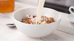Pouring Milk into the White Bowl Full of Crunchy Granola Cereals in Slow Motion - Powered by Shutterstock - Get 15% off with code: PIKWIZARD15