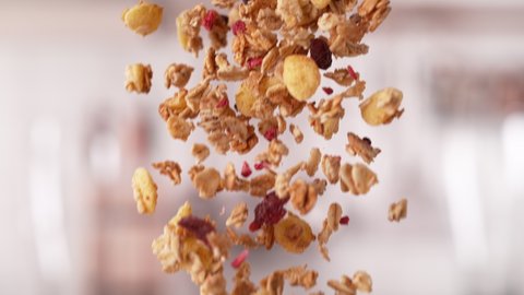 Handful of Crispy Granola Cereals Falling Down in a Batch in Slow Motion and Macro