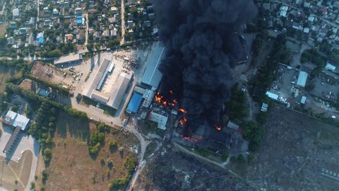 Severe fire in the warehouse. Black smoke in the sky. Drone filming over a large-scale fire. Grain video