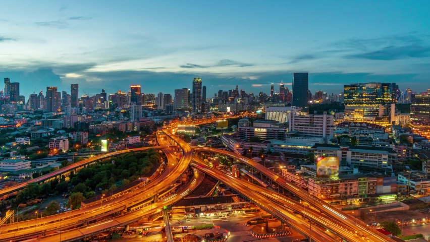 Time-lapse day to night,Of traffic on city streets at twilight, Timelapse of Bangkok Road roundabout with car Beautiful landmark in Business downtown in Thailand. Public transport Business District 