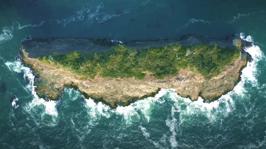 Breathtaking Top Aerial View of Small Island with Trees and Ocean Giant Waves Crashing at Rocky Cliff with Splashing and White Foam. Bird
