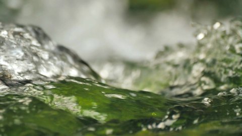 pure mountain water flows over rocks covered with moss