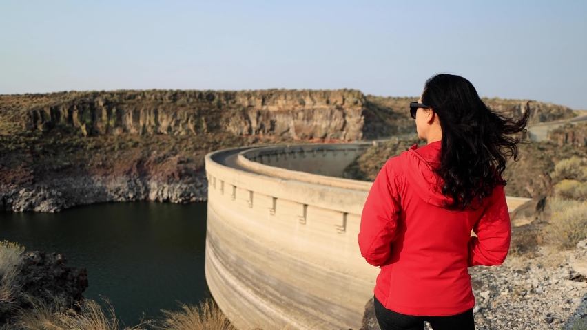 Asian woman hiking near the historic 100 year old Salmon Falls Dam in Southern Idaho