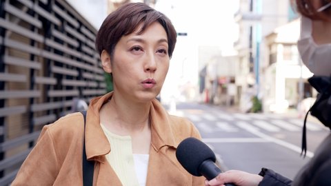 Asian woman undergoing a street interview.