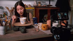 A female ceramicist is teaching about pottery in the workshop online.