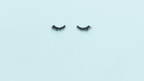 Stop motion 4k video with false eyelashes and accessories on blue background